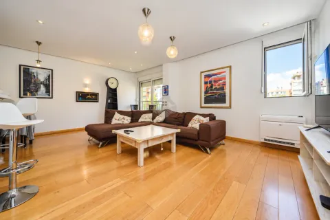 Spacious living room with a sofa, coffee table, and hardwood flooring. - image 14