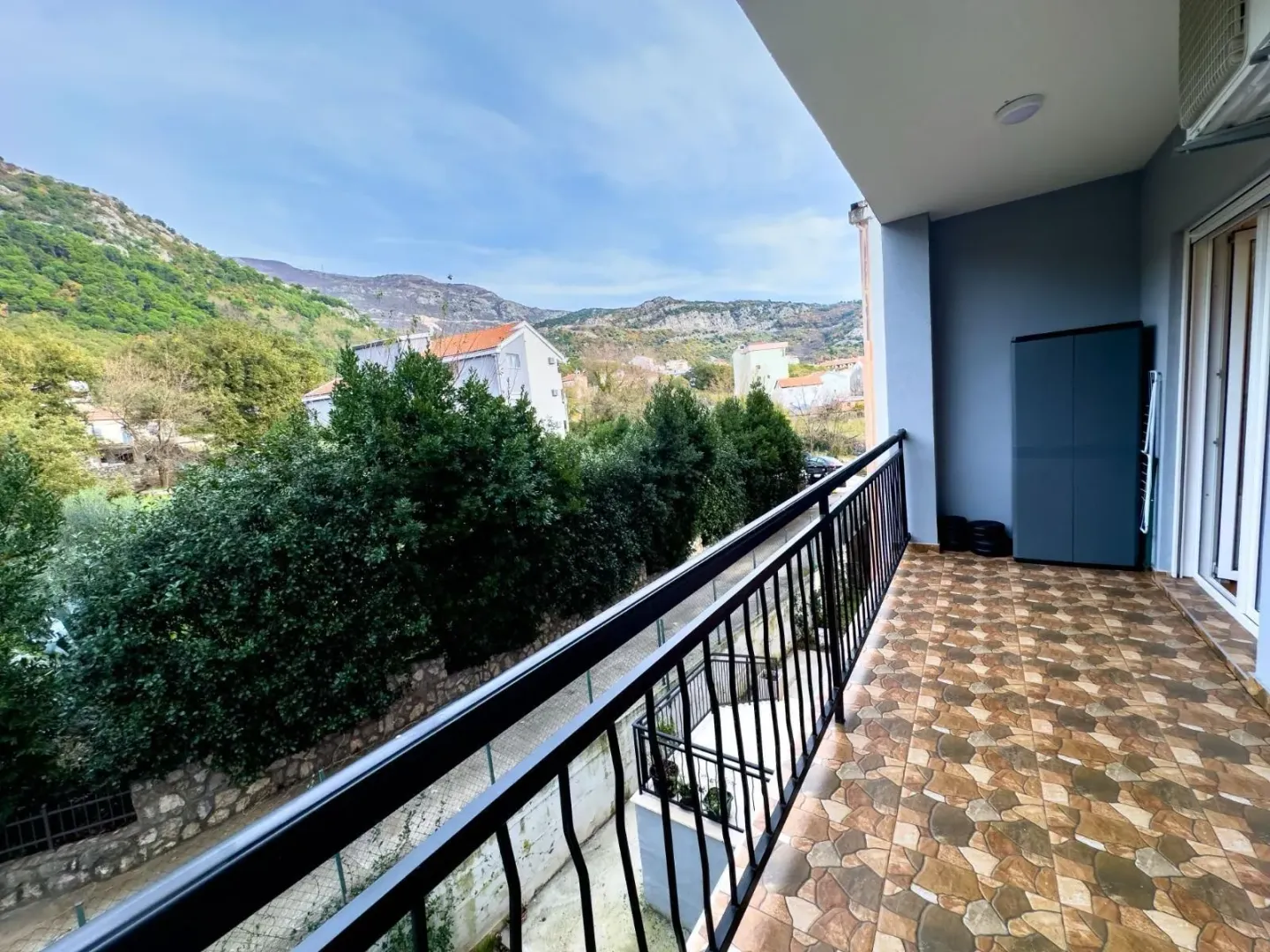 Natkriveni balkon sa pogledom na brda i okolno zelenilo.