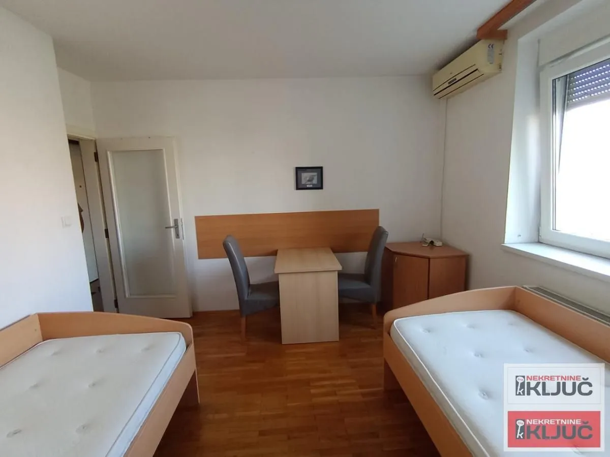 Bedroom with two single beds and a small table with chairs.