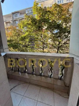 Manji popločani balkon sa pogledom na drveće i susedne zgrade. - image 15