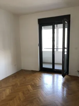 An empty room with parquet flooring and an open door leading to a balcony. - image 23