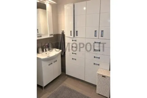 Bathroom with a washbasin, mirror, and white built-in cabinetry. - image 9