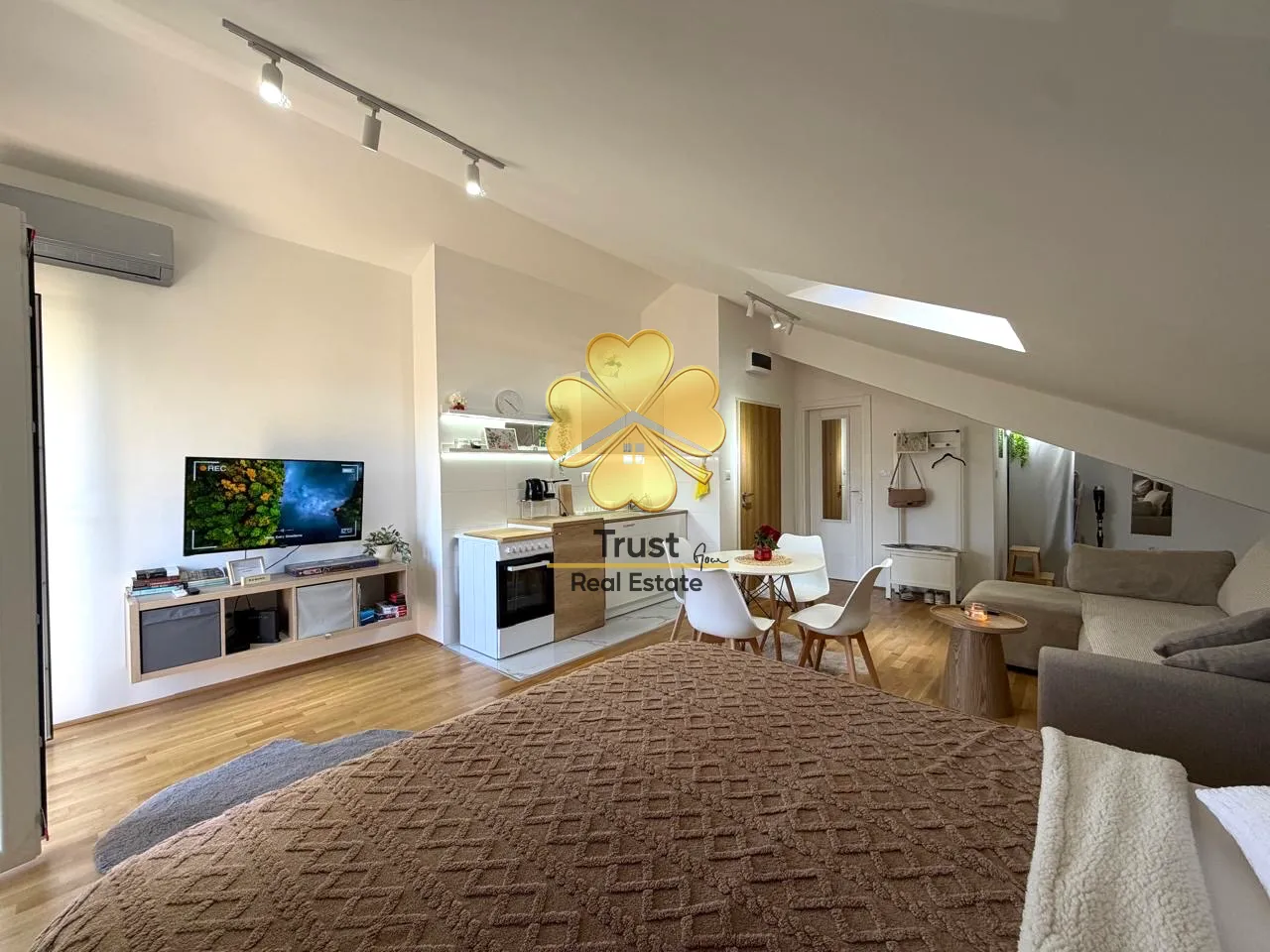 Spacious attic living room with kitchen and dining area.