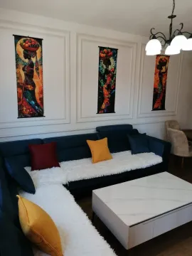Dnevna soba sa ugaonom garniturom, stočićem i ukrasnim slikama na zidu. - image 8