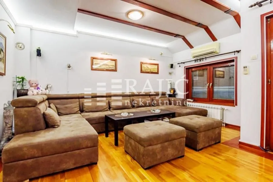Spacious living room with a sectional sofa and wooden ceiling details.