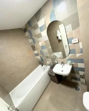 Modern bathroom with a bathtub, sink, and mirror. - image 2