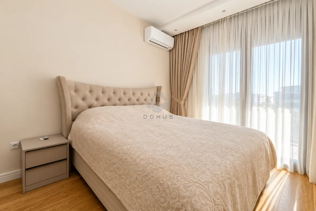 Spacious bedroom with a double bed, nightstand, and access to the terrace.