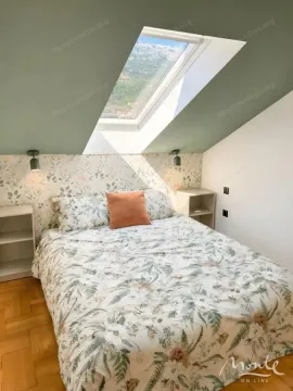Attic bedroom with a double bed, skylight, and parquet flooring. - image 13