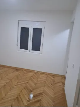 Prazna soba sa bijelim zidovima i drvenim podom. - image 9