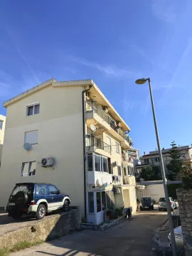 Spoljašnji izgled stambene zgrade sa parkiranim vozilima. - image 3