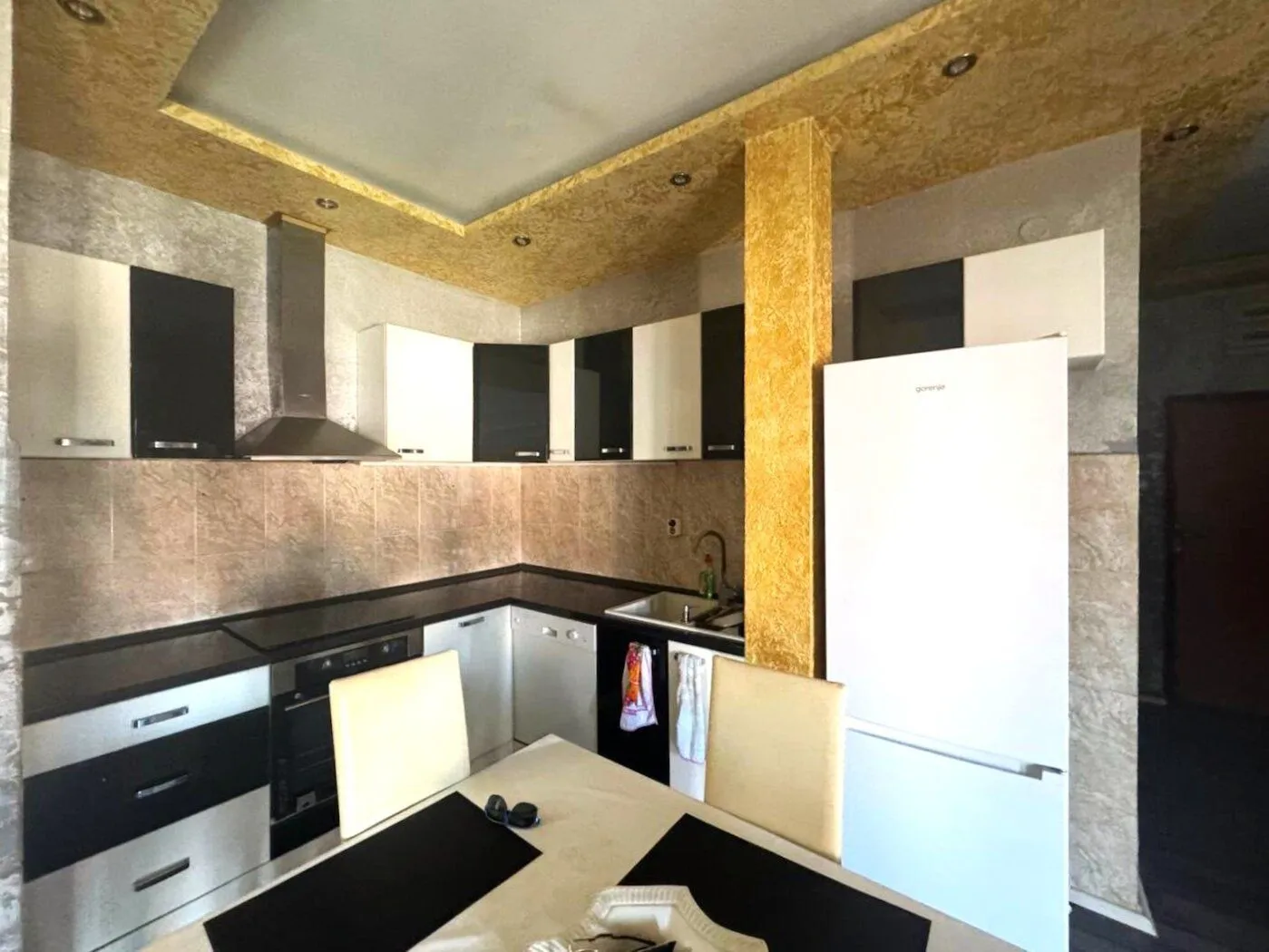 Equipped kitchen with a dining table and built-in appliances.