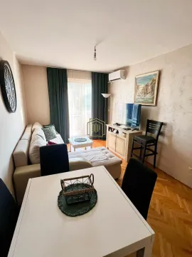 Living room with sofa, television, and dining table. - image 2