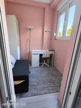 Manja spavaća soba sa krevetom, radnim stolom i ružičastim zidovima. - image 7