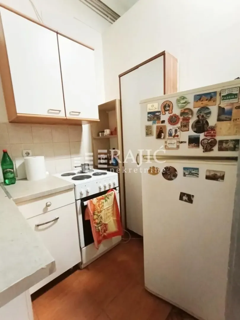 Small kitchen with basic elements and a refrigerator.