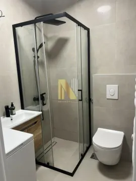 Modern bathroom with a shower cabin, washbasin, and toilet. - image 7