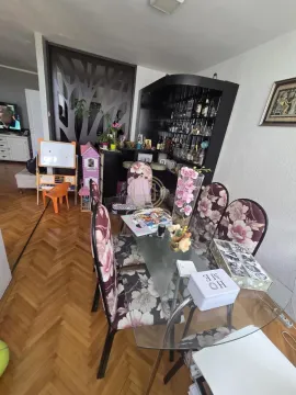 Living room with a dining table and floral patterned chairs. - image 4