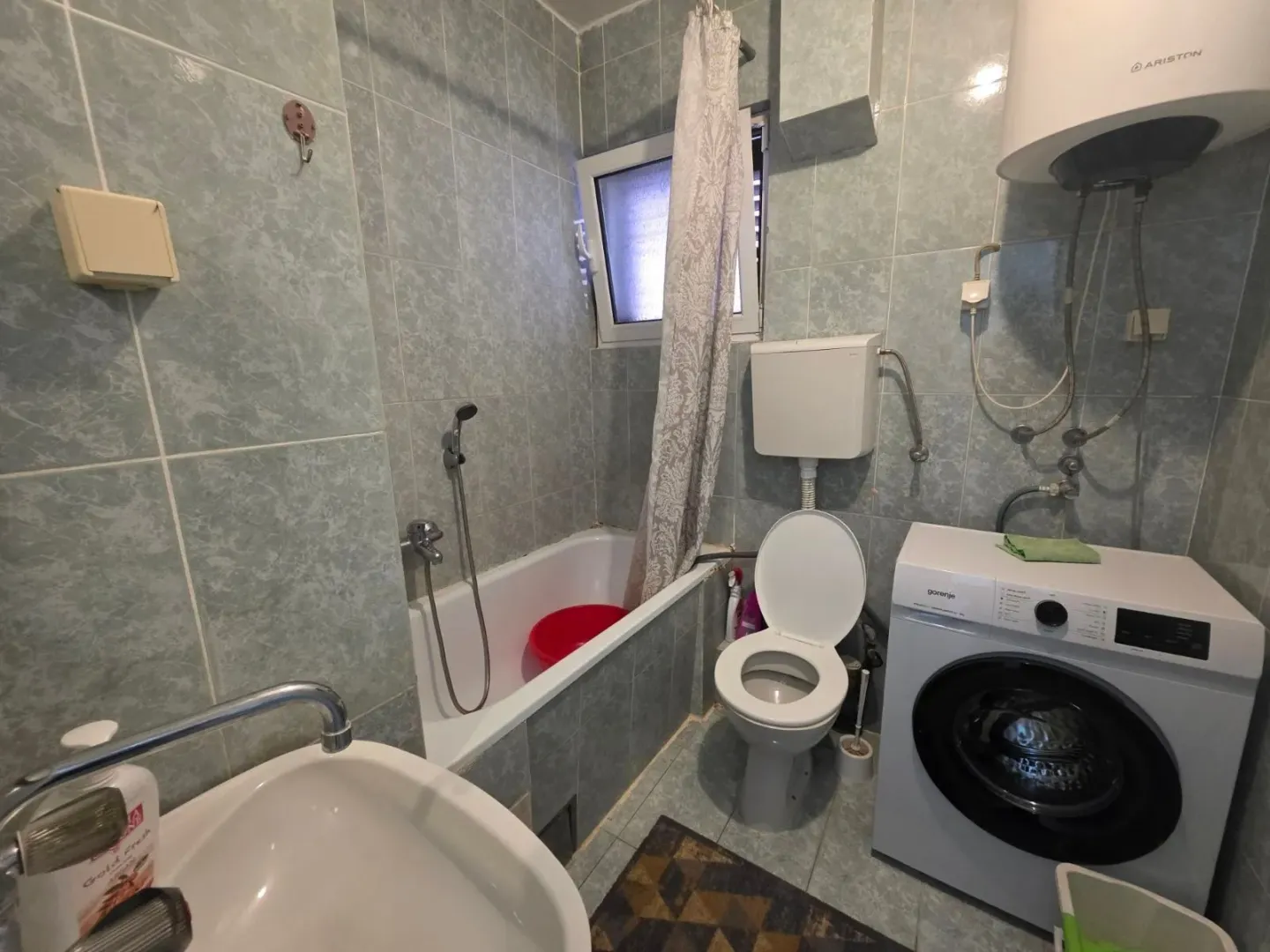 Bathroom equipped with a bathtub, toilet, and washing machine.