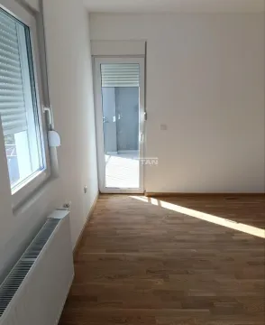 Prazna soba sa parketom i izlazom na terasu. - image 2