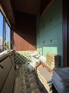 Zastakljeni balkon sa ugrađenim ormarima i skladištenim materijalom. - image 17