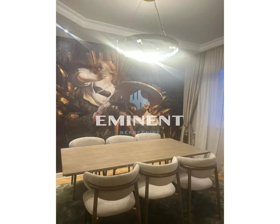 Dining area with a wooden table, modern chairs, and decorative wallpaper on the wall.