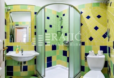 Small bathroom with a shower cabin, washbasin, and colorful tiles. - image 20