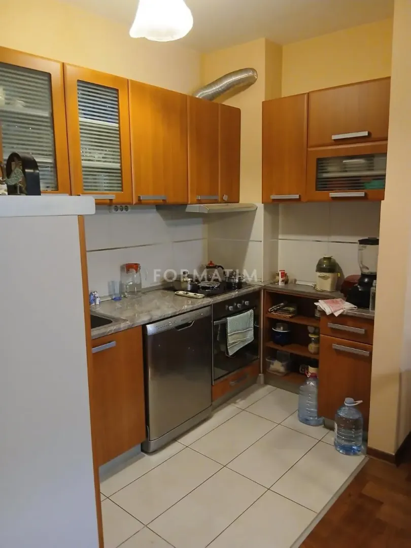 Manja kuhinja sa drvenim elementima i ugrađenim aparatima.