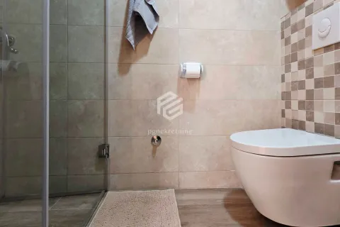 View of the bathroom with a walk-in shower and a wall-mounted toilet. - image 15