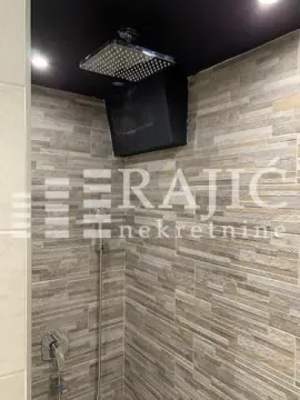 Modern shower cabin with a built-in rain shower head and stone wall cladding. - image 12