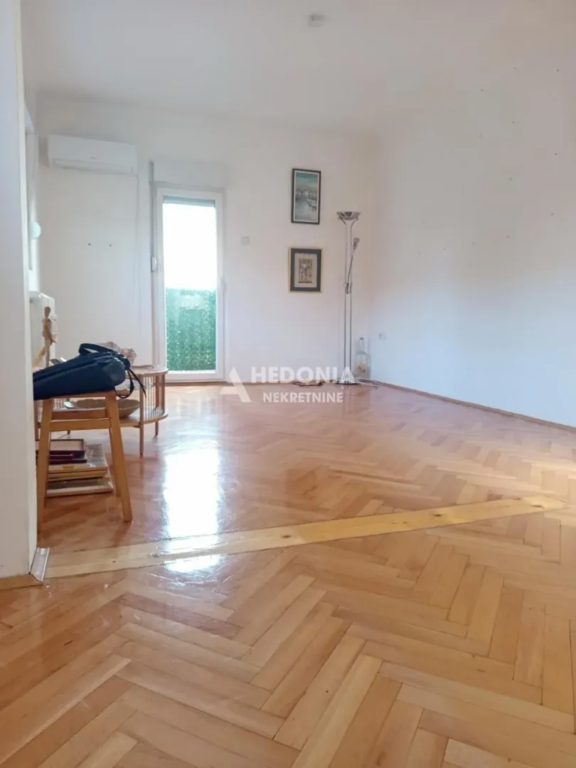 Empty living room with hardwood floors and access to the terrace.