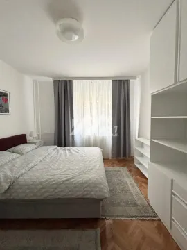 Nameštena spavaća soba sa bračnim krevetom, plakarom i prozorom sa zavesama. - image 5