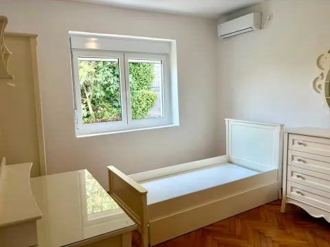 Small bedroom with a bed, white furniture, parquet flooring, and an air conditioning unit. - image 8