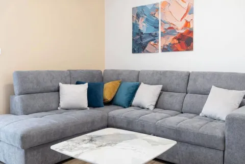 Comfortable living room with a corner sofa and decorative paintings on the wall. - image 7