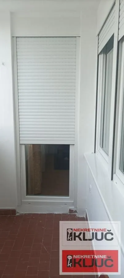 Zastakljeni balkon sa roletnama na prozorima.