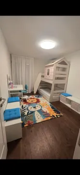 Children's bedroom with a bunk bed, desk, and colorful rug. - image 10