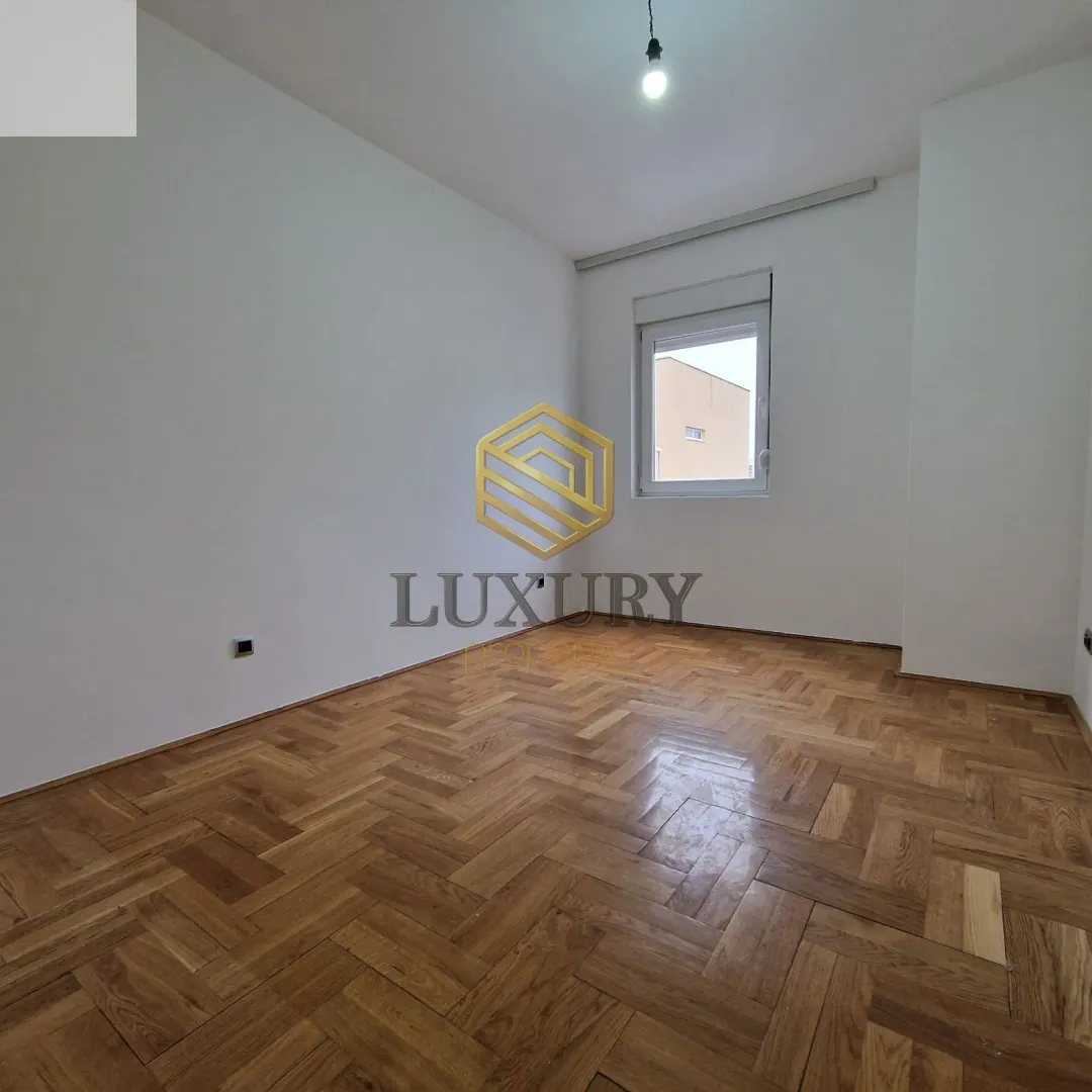 Empty room with parquet flooring and white walls.