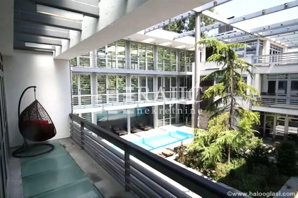 View from the terrace to the inner courtyard with a swimming pool and greenery.