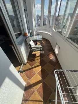 Enclosed balcony space with ceramic tiled flooring and patio furniture. - image 10