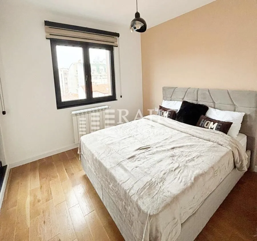 Furnished bedroom with a double bed and hardwood flooring.