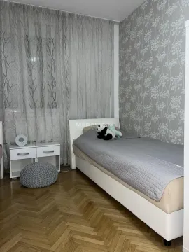 Bedroom with a bed, a bedside table, and wallpapered walls. - image 4