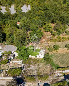 Pogled iz vazduha na staru kamenu kuću i plac okružen zelenilom. - image 8