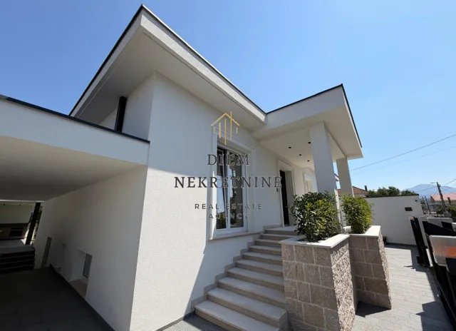 Eksterijer moderne kuće sa popločanim stepeništem i dvorištem.
