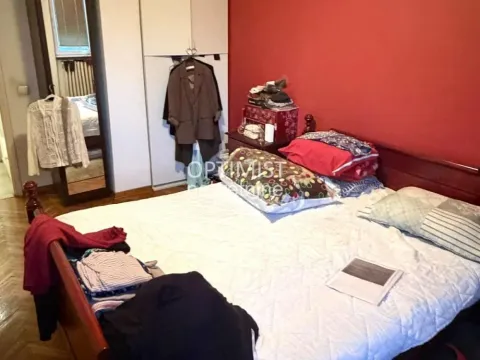 Nameštena spavaća soba sa bračnim krevetom, ormarom i crvenim zidom. - image 6