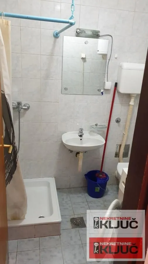 Manje kupatilo sa tuš kabinom, umivaonikom i toaletom.