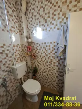 Smaller bathroom tiled with ceramic tiles, featuring a toilet and a shower cabin. - image 14