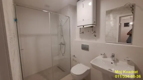 Savremeno opremljeno kupatilo sa tuš kabinom, umivaonikom i wc šoljom. - image 5