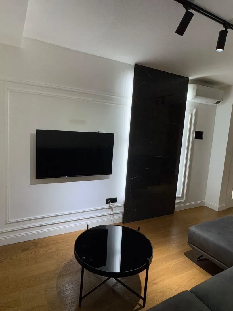 Living room with a modern wall panel, television, and sofa.