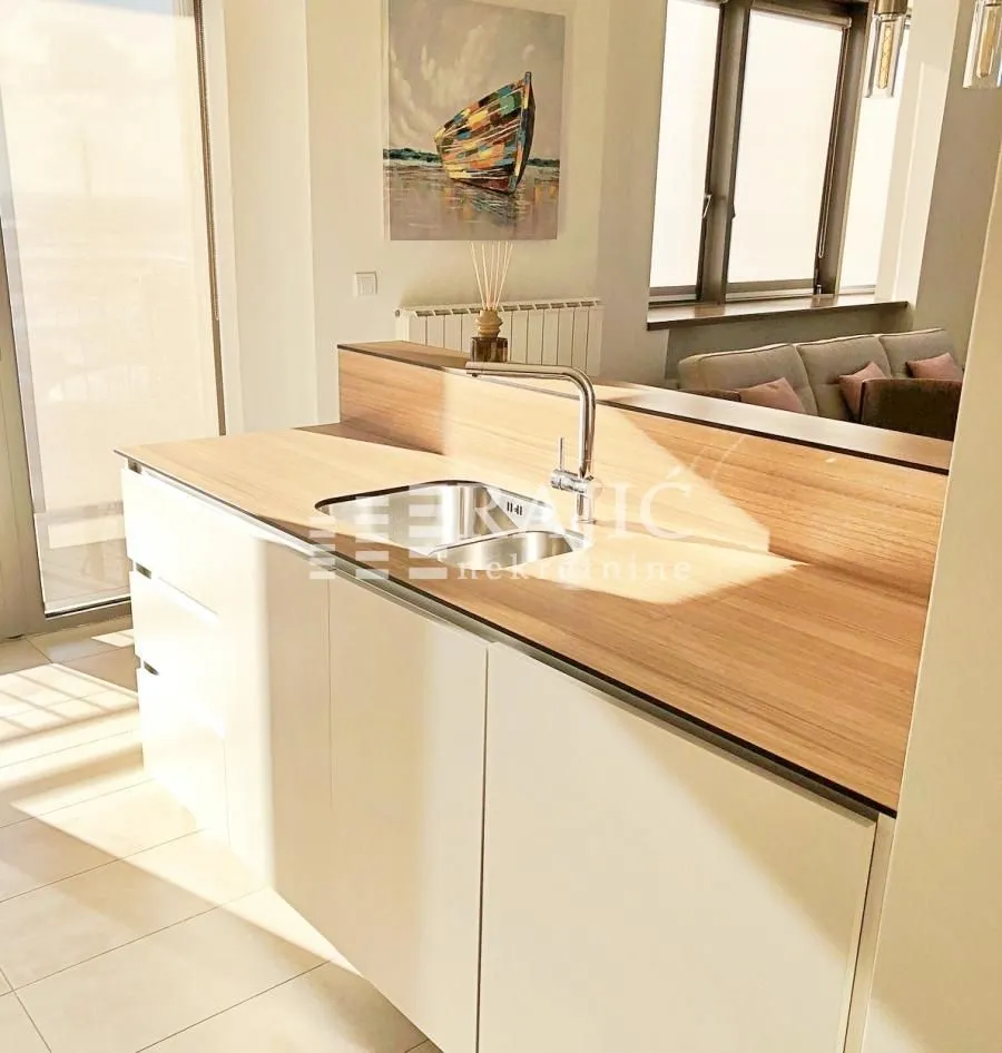 Modern kitchen with a breakfast bar and a view of the living room.