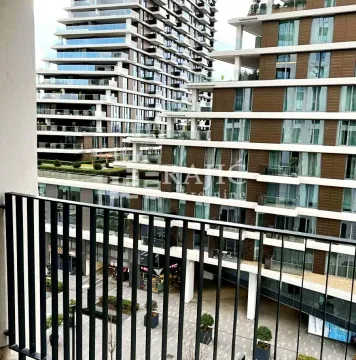View from the balcony overlooking modern residential buildings and courtyard. - image 15