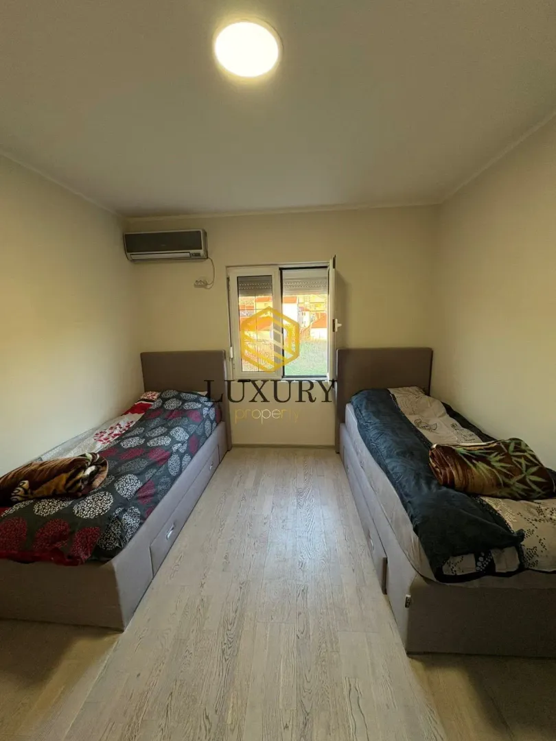 Bedroom with two single beds and an air conditioning unit.