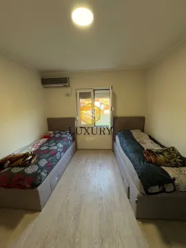 Bedroom with two single beds and an air conditioning unit. - image 12